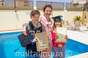A mother with her 2 children who have both completed a language course
