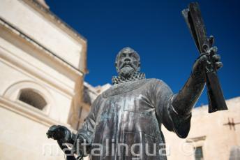A statue in Malta of a man holding a scroll