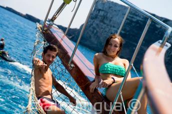 2 students lounging on the deck of a boat at Comino in Malta.