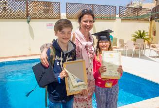 A mother with her 2 children who have both completed a language course
