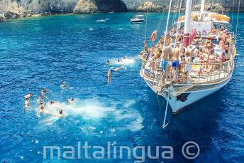 Language students jumping off a boat at Crystal Bay, Comino.