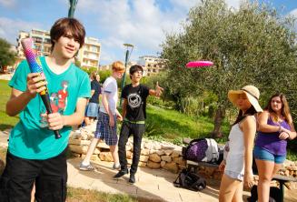 Students playing baseball and frisbee at the residence park