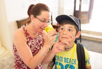 A staff member putting face-paint on a child