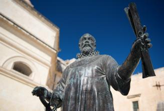 A statue in Malta of a man holding a scroll