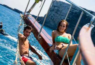 2 students lounging on the deck of a boat at Comino in Malta.