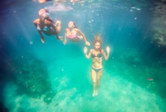 3 friends swimming underwater.